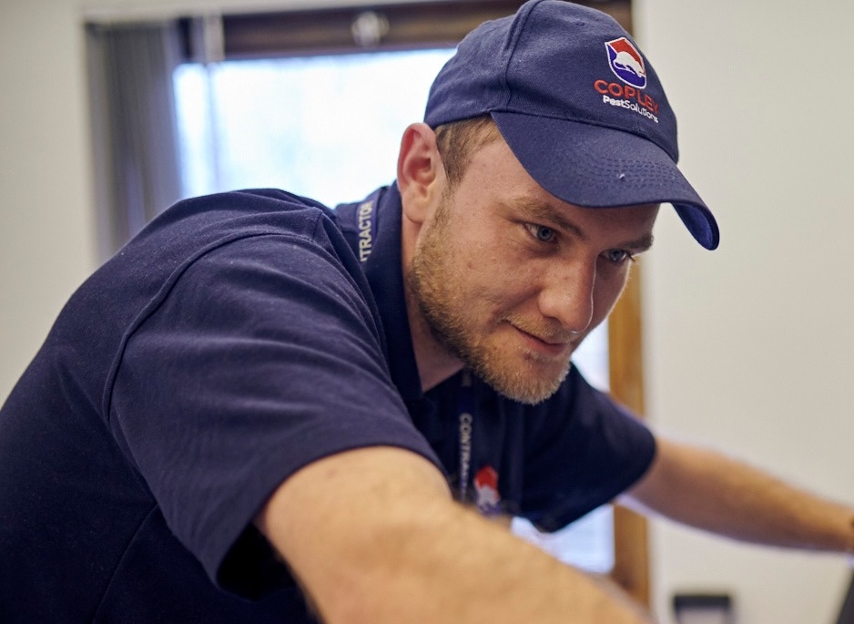 Copley pest technician wearing a branded hat